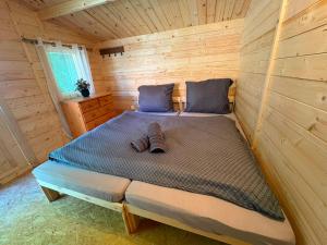 a bed in a wooden room in a cabin at Glamping 68 - Summer cottage in Kámen