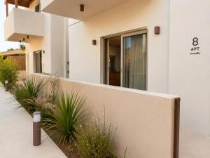 a white house with plants in front of it at MIRA MARE - Apartments 1 & 8 in Stavros +34 photos