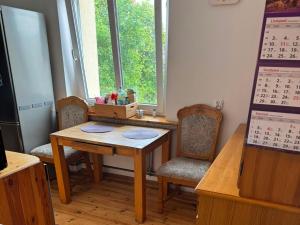 a table and chairs in a room with a calendar at Apartament Dworcowa in Kołobrzeg