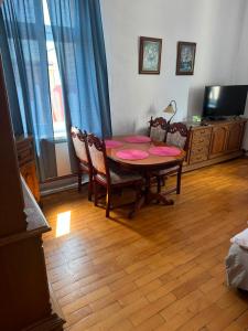 a dining room with a table and chairs and a television at Apartament Dworcowa in Kołobrzeg