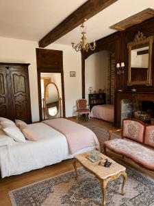 a bedroom with a bed and a table and a couch at Château de Taussac in Taussac