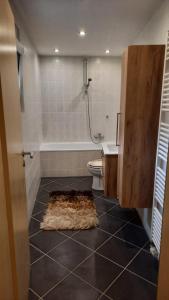 a bathroom with a shower and a rug on the floor at Gästezimmer Heinebach in Alheim