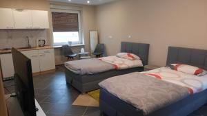 a room with two beds and a kitchen with a counter at Gästezimmer Heinebach in Alheim
