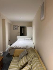 a bedroom with a bed and a couch in it at Quiet Double Room Ensuite Marble Bathroom South Croydon in Croydon