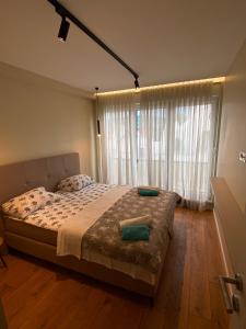 a bedroom with a bed and a large window at Vista Visoko Apartants in Visoko