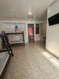 a room with a large tile floor and a room with bunk beds at Villa Tania in Melgar