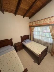 a bedroom with two beds and a window at La muñeca Chalet in Circasia +28 photos