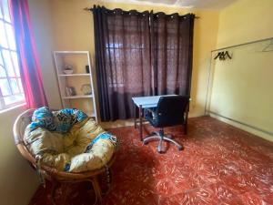 a living room with a table and a chair and a table at Homestay in Wilkinson road in Freetown