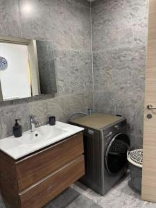 a bathroom with a sink and a washing machine at Bel appartement in Cheraga +13 photos
