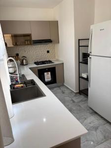 a kitchen with a white counter top and a refrigerator at Bel appartement in Cheraga