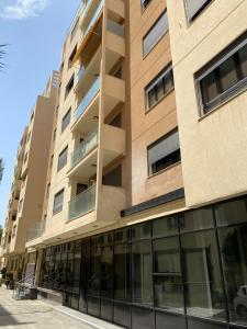 an apartment building with glass windows on a street at Bel appartement in Cheraga