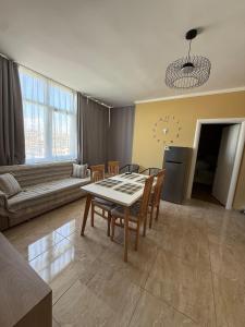 a living room with a table and chairs and a couch at Durres-apartament in Durrës