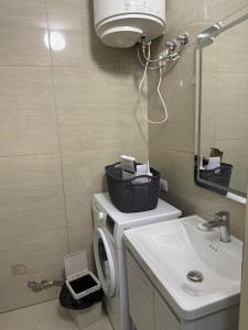 a bathroom with a washing machine and a sink at Durres-apartament in Durrës
