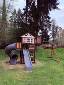 a playground with a play structure and a slide at Tranquility Place in Oak Harbor