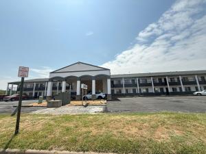 a large building with a parking lot in front of it at Budget Host Inn in Salina