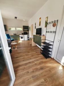 a living room with wood floors and a kitchen at Hikers place in Sutomore