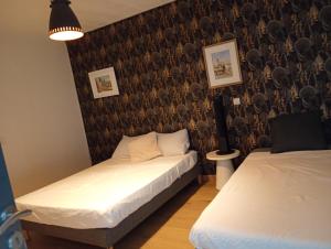 a bedroom with two beds and a wall with a wallpaper at Iris in Valras-Plage