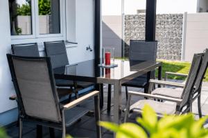 a black dining table and chairs on a patio at Cosima in Hohenroth