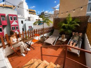two people sitting on the balcony of a building at Kite & Surf Nomad House in Las Palmas de Gran Canaria
