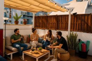 a group of people sitting on a couch on a patio at Kite & Surf Nomad House in Las Palmas de Gran Canaria