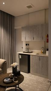 a kitchen with a counter and a table in a room at Sukoon in Dammam