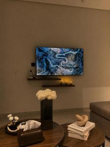 a living room with a tv and a coffee table at Sukoon in Dammam