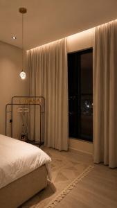 a bedroom with a bed and a large window at Sukoon in Dammam