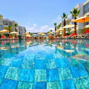 a swimming pool at a resort with umbrellas at 2BR Pool View Kids Pool & Gym 6 Min to Beach in Dar Hamida +9 photos
