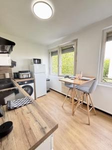 a kitchen with a table and a dining room at Bricks Pérignon - Tram, lit Queen size & air fryer in Chenôve
