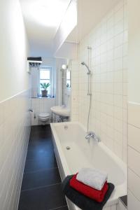 Baño blanco con bañera y lavamanos en Ferienwohnungen Apartements Buddestrasse Daberstedt, en Erfurt