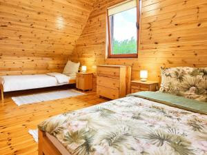 a bedroom with a bed and a window in a log cabin at Morenowa Dolina Rusinowo in Rusinowo