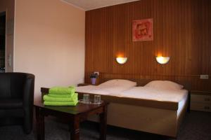 Un dormitorio con una cama y una mesa con una toalla verde en Eifelhotel Malberg, en Malberg