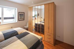 een slaapkamer met een bed en een grote kast bij Ferienwohnungen Apartements Buddestrasse Daberstedt in Erfurt