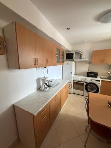 a kitchen with wooden cabinets and a table in it at GZP Residence Lugoj 2 in Lugoj