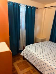 a bedroom with a bed and a blue curtain at Little Escape in The Lime