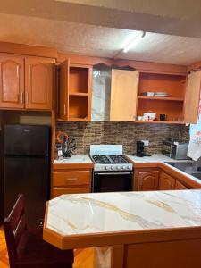 a kitchen with wooden cabinets and a stove top oven at Little Escape in The Lime