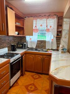 a kitchen with a stove and a sink and a window at Little Escape in The Lime +4 photos