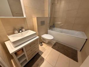 a bathroom with a sink and a tub and a toilet at Seyra Olive Studio in Ştefăneştii de Sus +23 photos