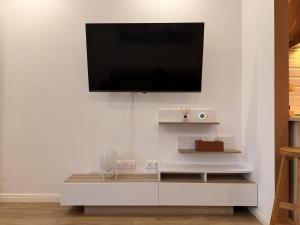 a living room with a tv on a white wall at Seyra Olive Studio in Ştefăneştii de Sus