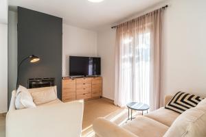 a living room with a couch and a tv at Villa Gagra - Villa by the Sea with a Private Pool in Panormos Rethymno +39 photos