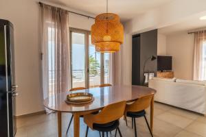 a dining room with a wooden table and chairs at Villa Gagra - Villa by the Sea with a Private Pool in Panormos Rethymno