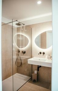 a bathroom with a shower and a sink and a mirror at Stella Marina Budoni in Budoni +148 photos