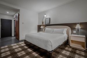 ein Schlafzimmer mit einem großen weißen Bett und einem Flur in der Unterkunft Hotel Longmont in Longmont