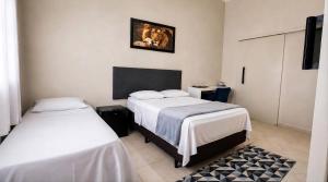 a bedroom with two beds and a television in it at Cantinho Da Go in Caraguatatuba