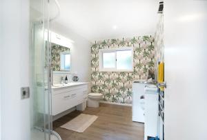a bathroom with a shower and a toilet and a sink at Waikanae Beach Suite Retreat in Waikanae +53 photos