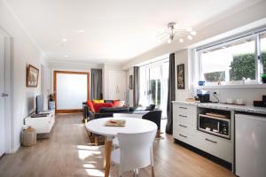 a kitchen and living room with a white table at Waikanae Beach Suite Retreat in Waikanae