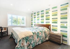 a bedroom with a bed and a wall of plates at Waikanae Beach Suite Retreat in Waikanae