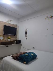 a white room with a bed and a flat screen tv at Donde poyito in Sevilla
