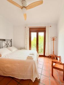 a white bedroom with a bed and a window at Casa luminosa con encanto in Vélez-Rubio