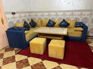 a living room with a blue couch and a table at Omarkad in Taourirt